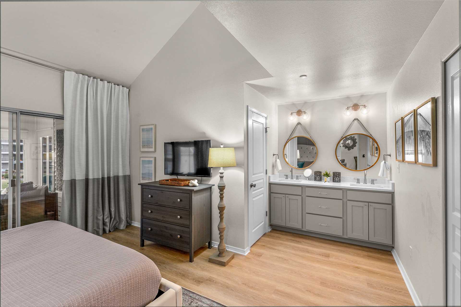 The connected bathroom has two sinks and a shower/ tub combo