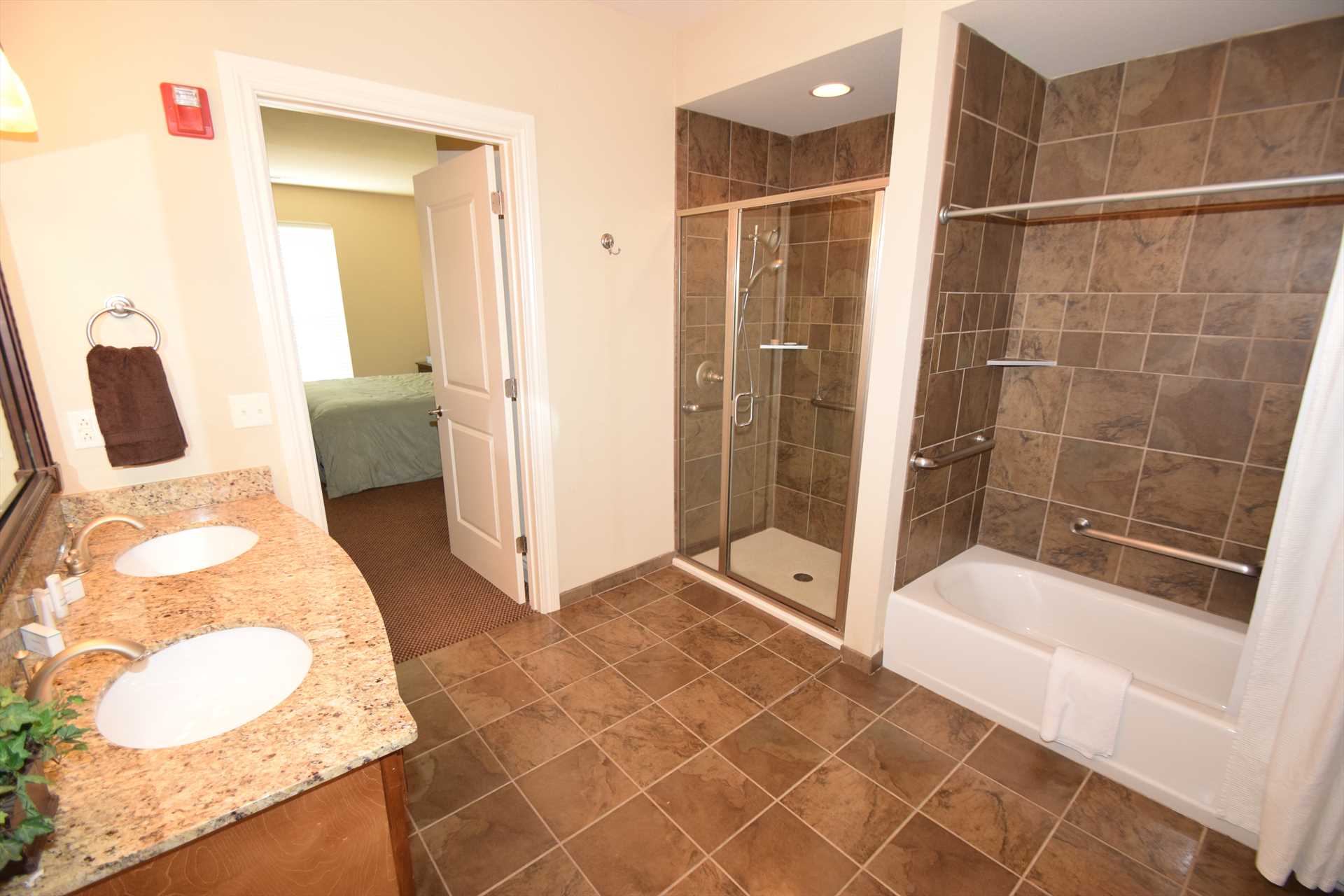 This spacious bathroom includes a tub and a walk-in shower.