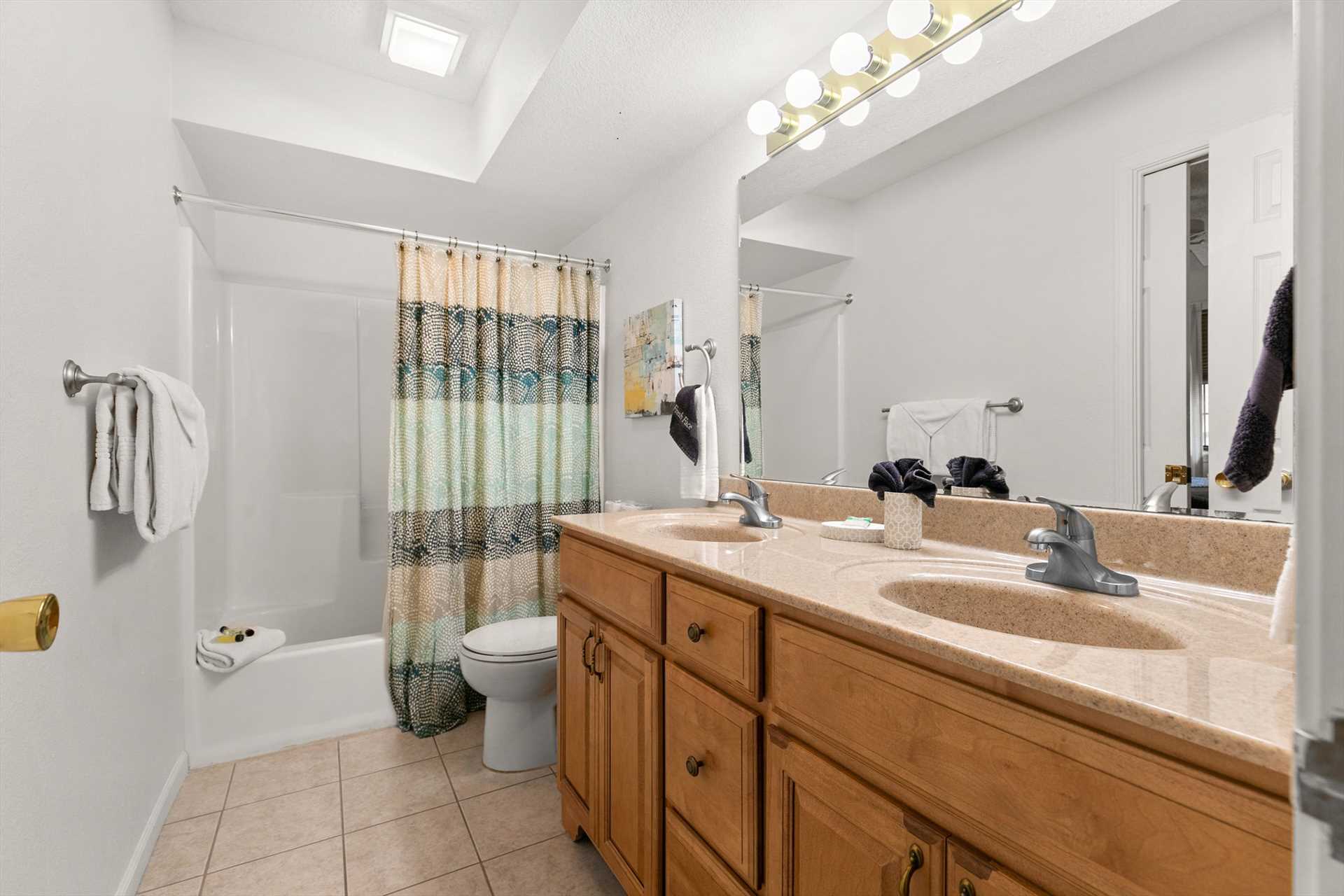 This bathroom also has double sinks and a shower tub combo.