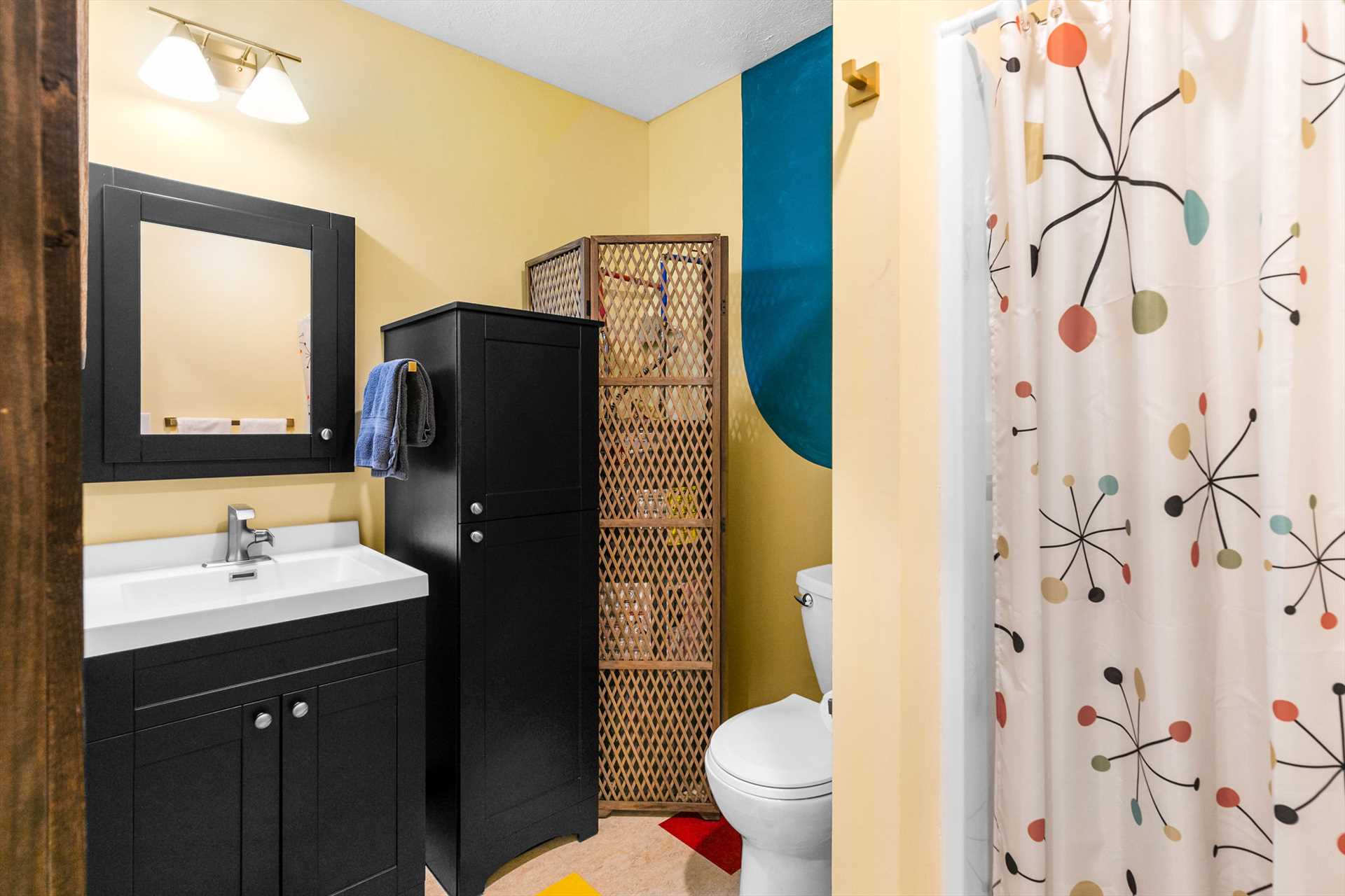 The bathroom has a stall shower and plenty of storage.