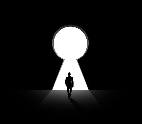 person walking into a giant key hole
