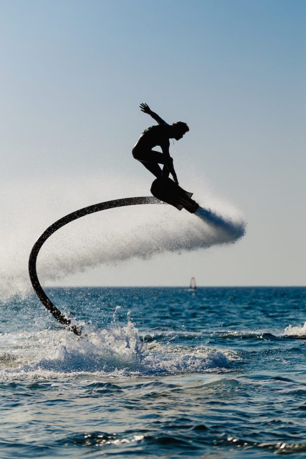 Silhouette of a hover board rider at sea