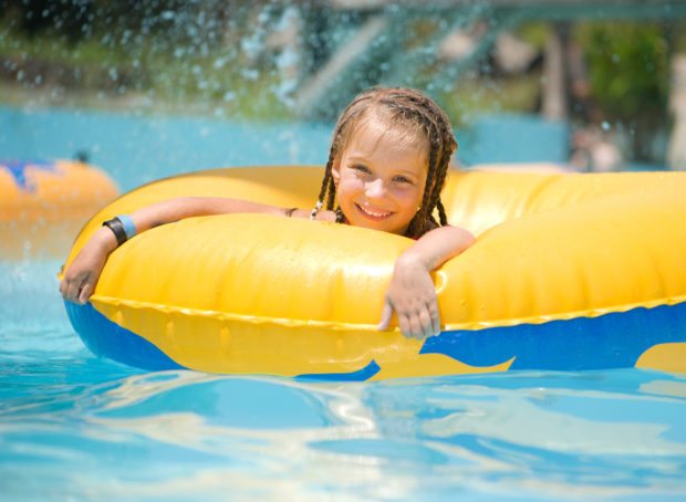 young girl in inner tube at water park, smiling