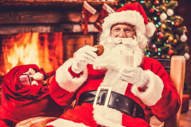 Photo of Santa Claus near a Fireplace. Click Here to Learn More about a Branson Christmas Vacatiton.