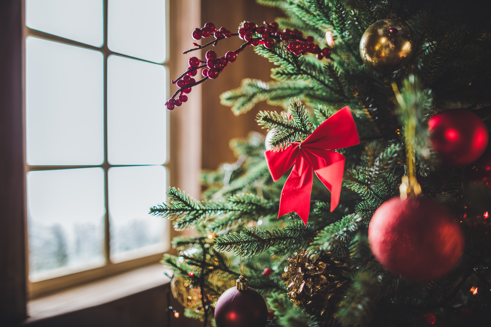 Close-up of Christmas tree with ornaments, bows, and berries