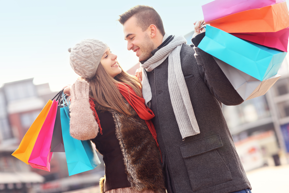 Cheerful young people with shopping bags in winter
