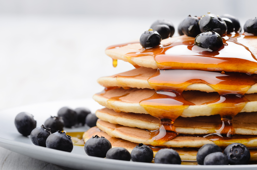 Pancakes close up, with fresh blueberries and maple syrup