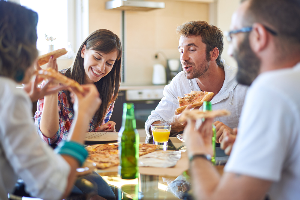 Young people eating pizza and talking