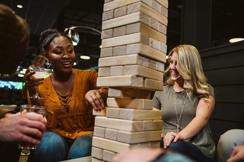 view of two women playing jenga with a drink in hand: indoor activities in Branson MO