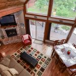 loft view of cabin living room, dining table, and patio