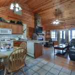 Branson vacation cabin kitchen, dining table, and living room with fireplace